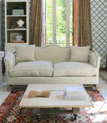 Sofá tapizado con respaldo ondulado y base de roble
