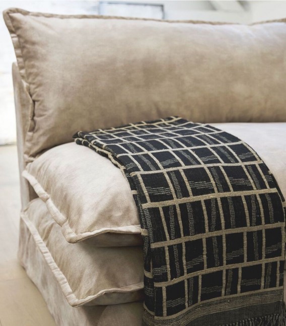 Detalle sofa tipo futon con almohadones de terciopelo marrón
